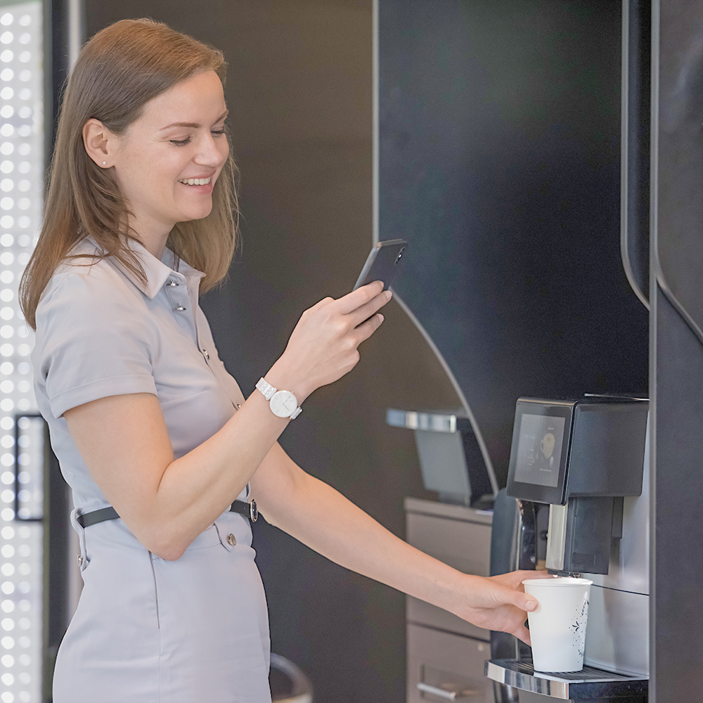 Woman ordering coffee using SwiftVend on mobile phone